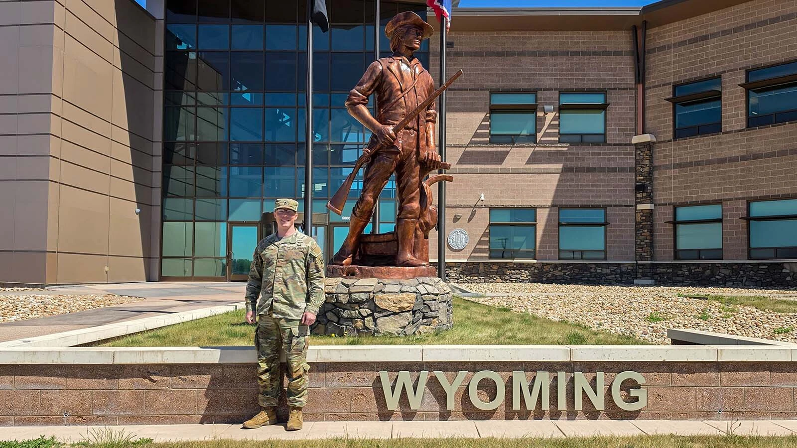 Sgt. 1st Class Clive Rieke, Wyoming Army National Guard AGR Program NCOIC, poses for a photo in front of the Wyoming Minuteman statue outside Joint Force Headquarters in Cheyenne. The statue honors the citizen-Soldier tradition and symbolizes the Wyoming National Guard's commitment to serving both state and nation.