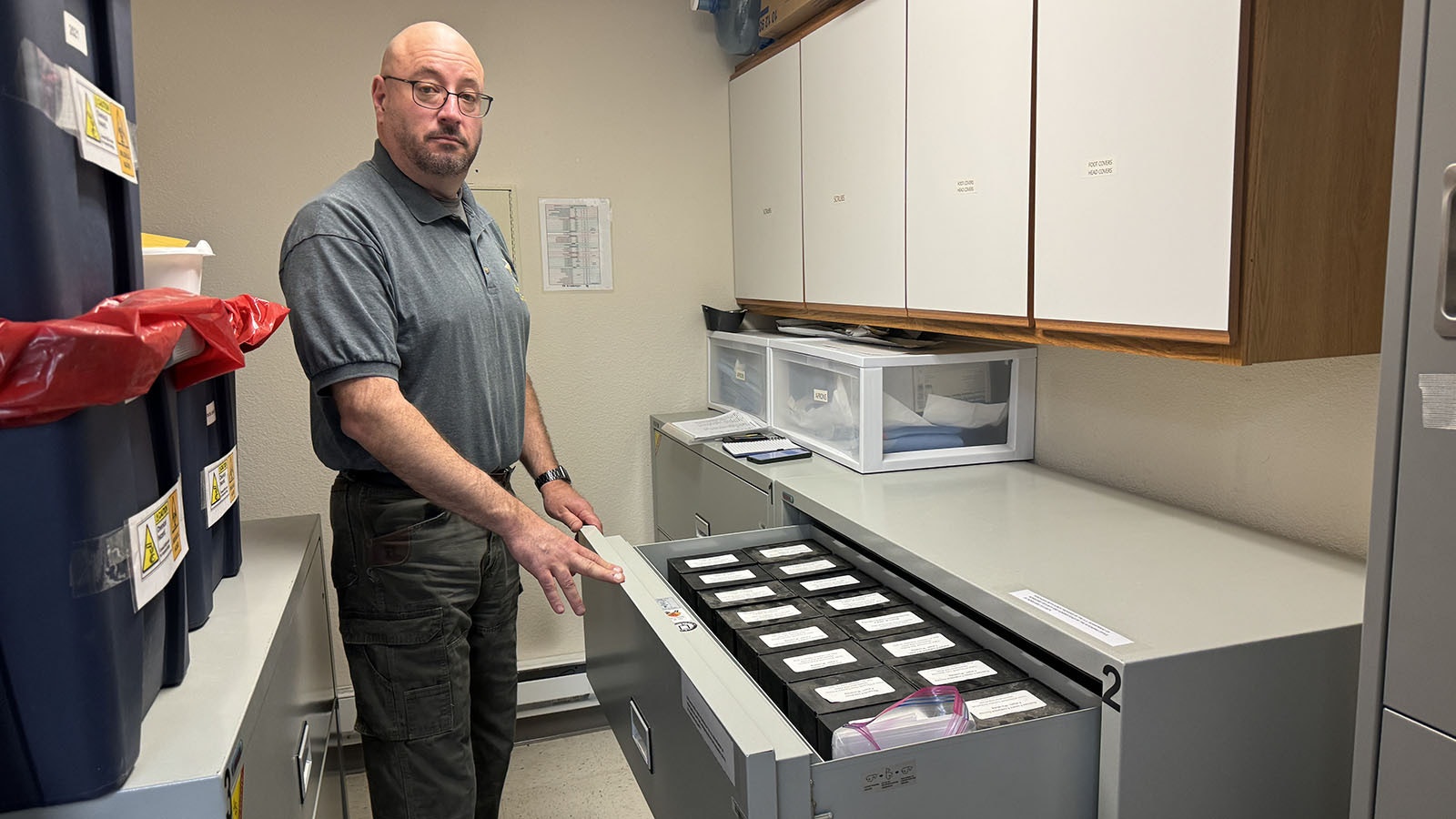 Natrona County Coroner James Whipps keeps the cremated remains of indigent people contained in square, box-shaped urns in a fireproof filing cabinet in one of his offices until he can find next-of-kin.