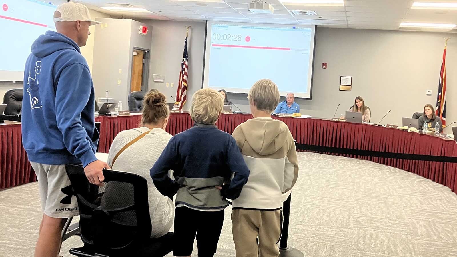 A family addresses the school board about the closing of Woods Learning Center.