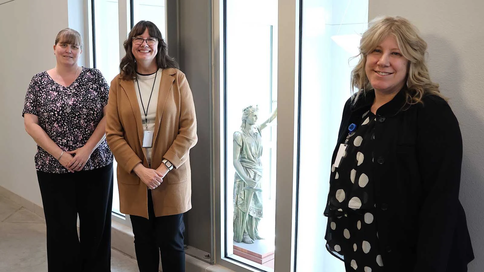 Deputy clerks Michelle Brown, left, Carol Korell and Natrona County Clerk of District Court Jill Kiester pose with Natrona County’s symbol of legal justice that was once on the county’s original court building.
