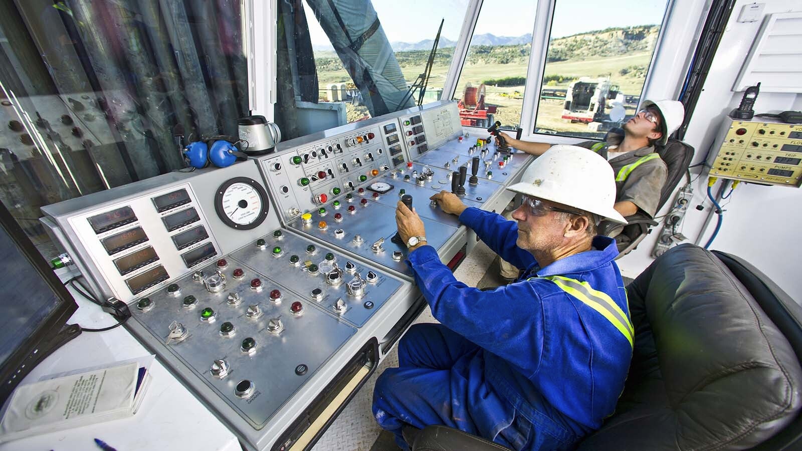 A pair of technicians work in the control room on the platform of a natural gas drilling rig in this file photo.