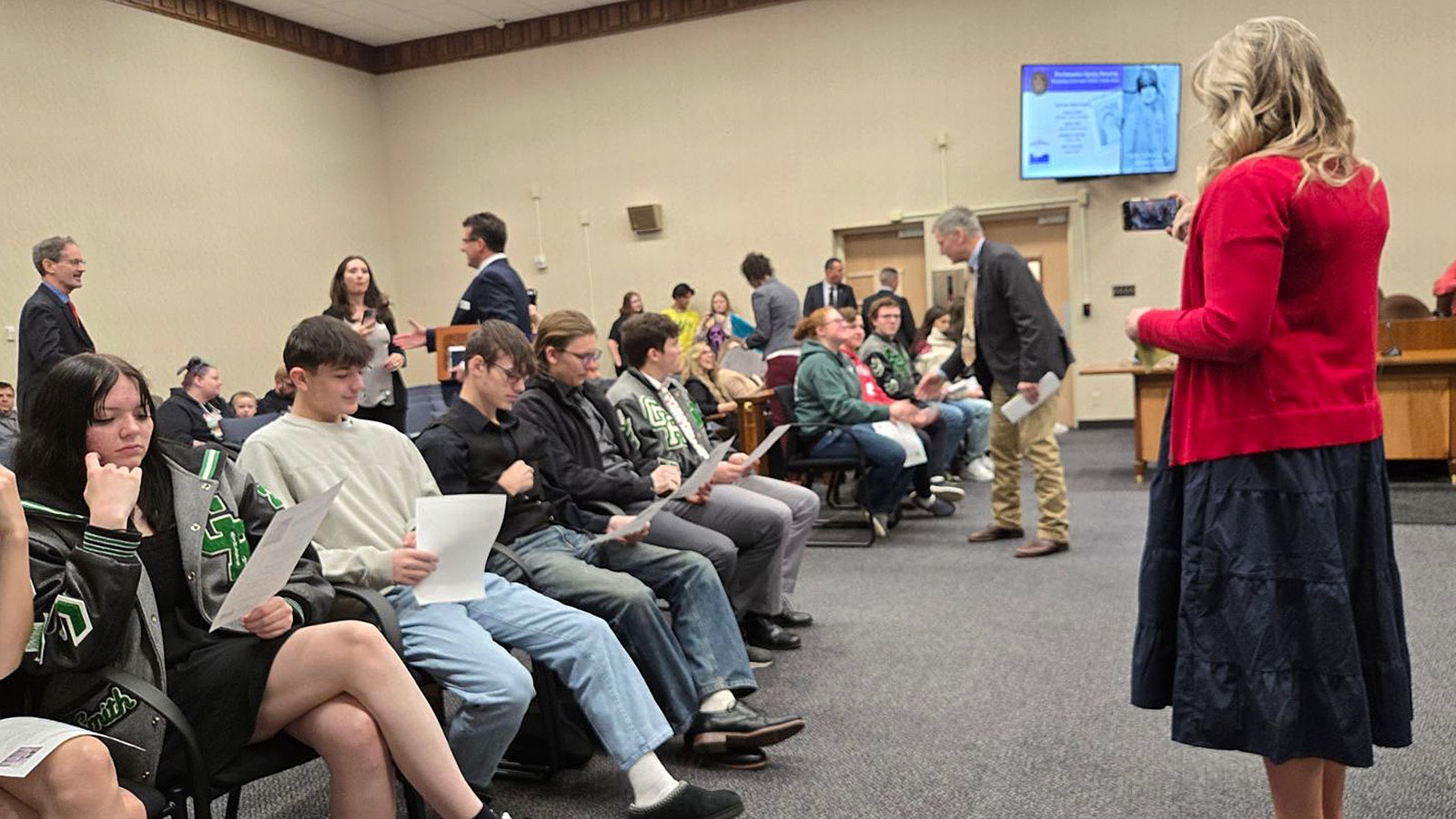 Teacher Bridgette Nielsen looks on as Gov. Mark Gordon congratulates her Green River High School Social Studies class for writing the Nellie Tayloe Ross Day Proclamation.