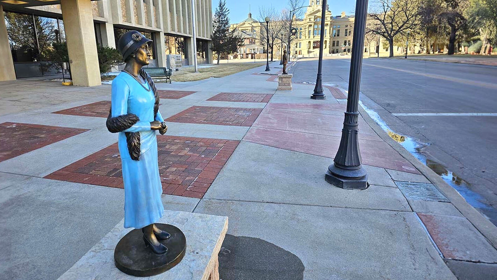 Nellie Tayloe Ross, first female Wyoming governor, looks sharp as if about to turn and walk to Wyoming’s state Capitol in the background.