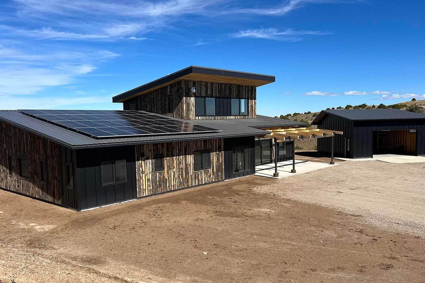 The net zero house has a modern look with materials and design that fit well with Wyoming and a rural landscape.