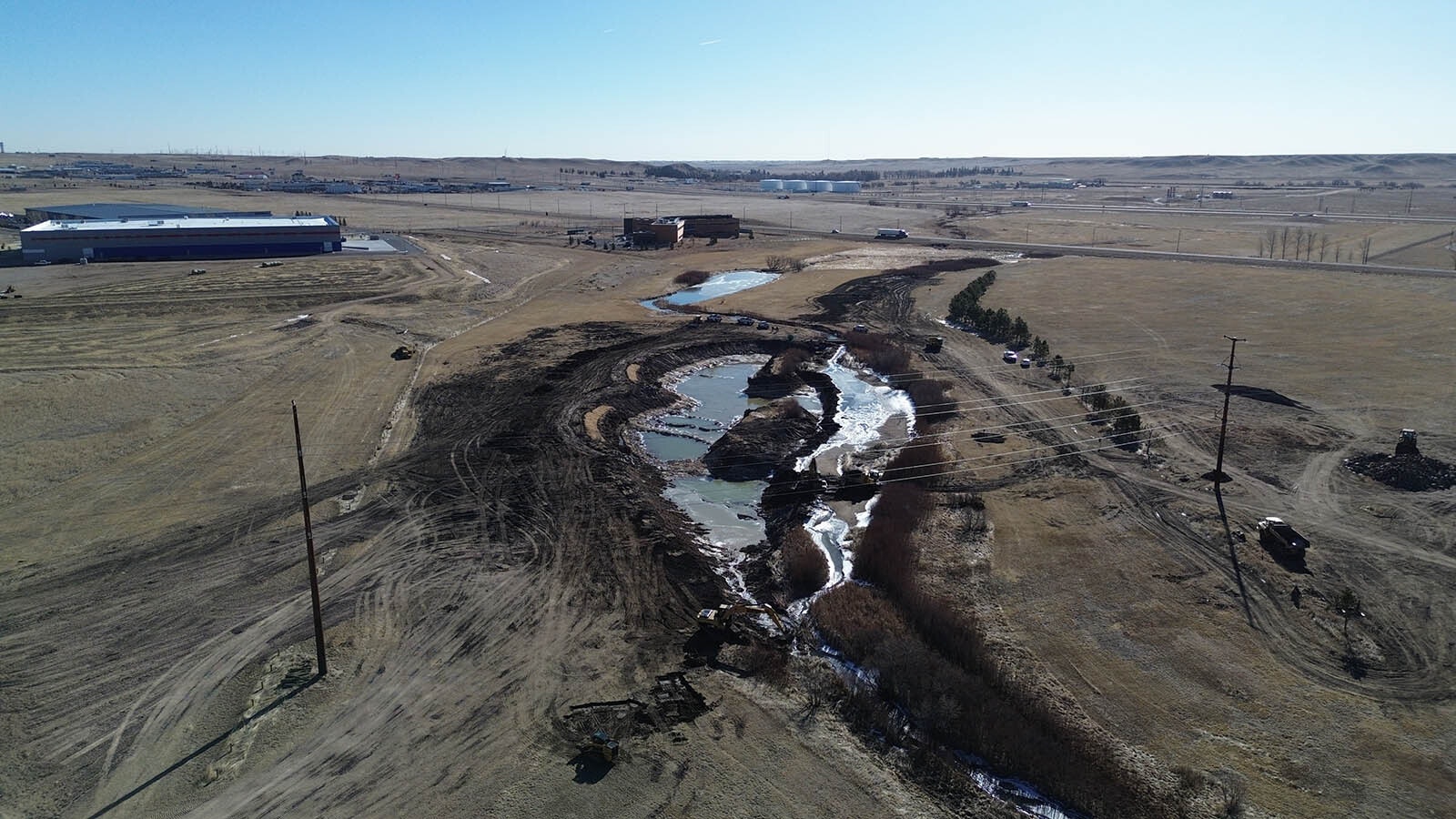This view, looking southeast and downstream on Dry Creek, shows the extent of a fishing pond project on the Cheyenne Business Parkway. The Eagle Claw fishing gear factory is visible on the left.