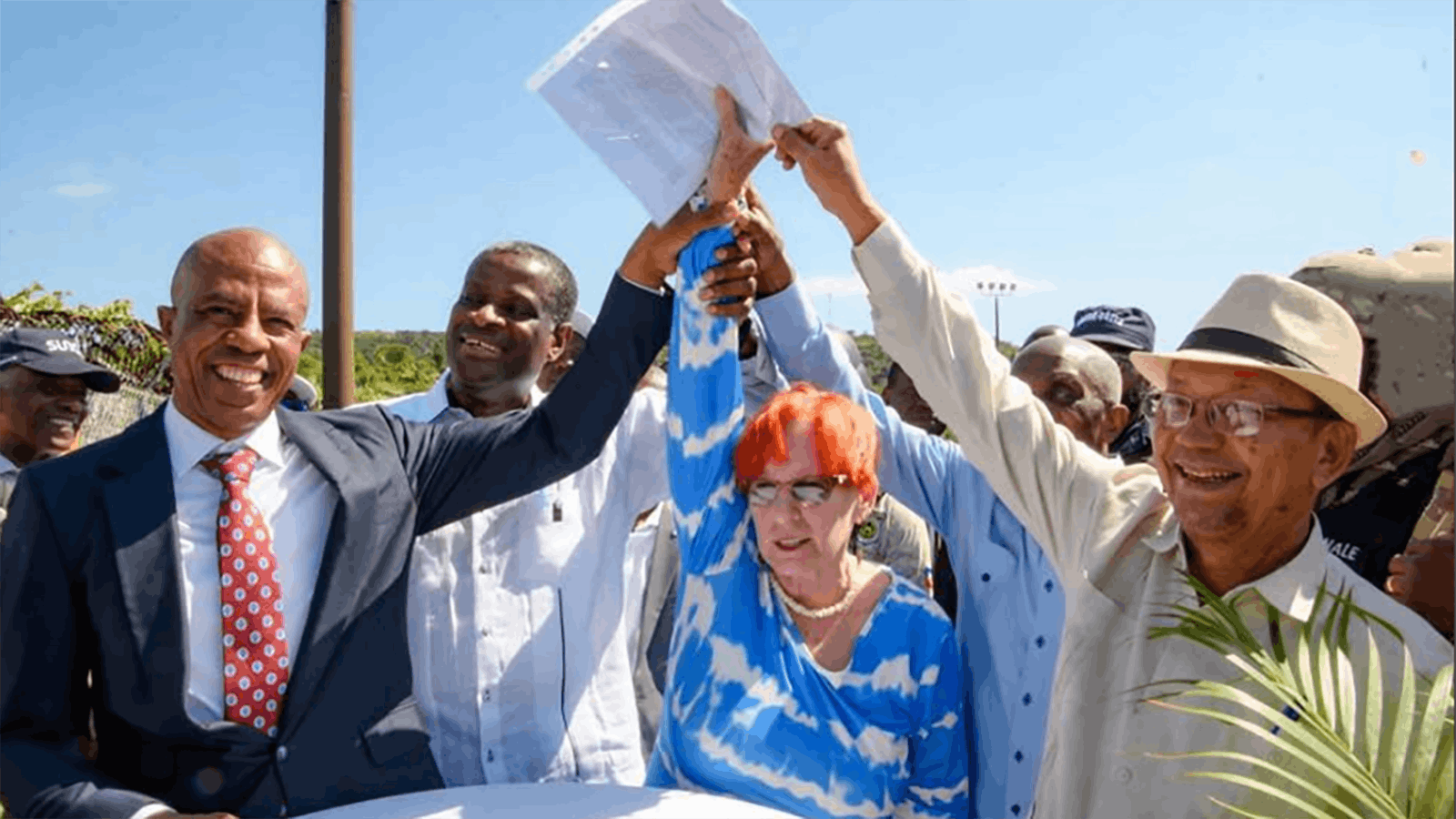 Hands raise in victory during a port inauguration ceremony just after signing the contract for the port with the Haitian government. From left are: Jocelin Villier, director general of the National Port Authority; Alfred Metellus, minister of finance; Anne Hauge, third-generation owner of Snake River Ranch in Jackson Hole, Wyoming; and Leslie Voltaire, president of Haiti.