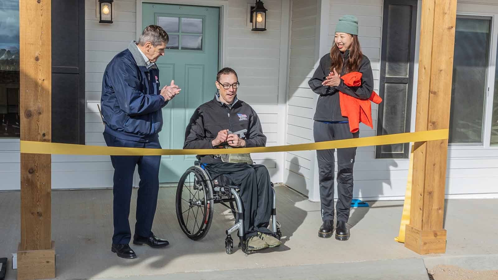 Bryan Price, his wife, Siqi, and Homes For Our Troops Executive Director Bill Ivey, prepare for the ribbon cutting ceremony at the Price home southwest of Casper.