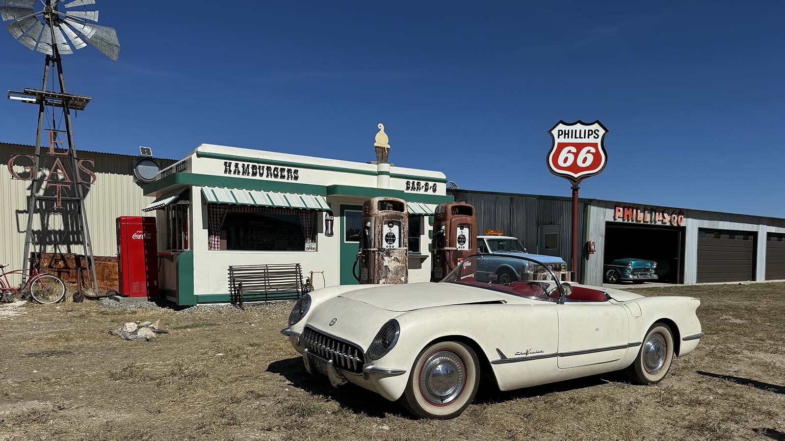 A 1954 Corvette parked in front of vintage gas pumps standing in front of the Nifty Niner diner restored by Ken Quintiliani.