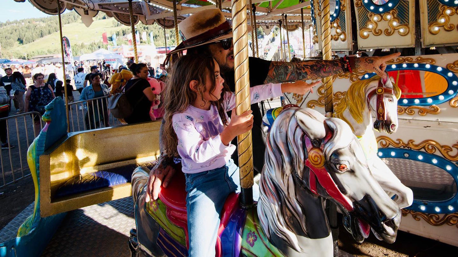 Mötley Crüe bassist Nikki Sixx on the carousel with daughter Ruby, 4, at the Teton County Fair.