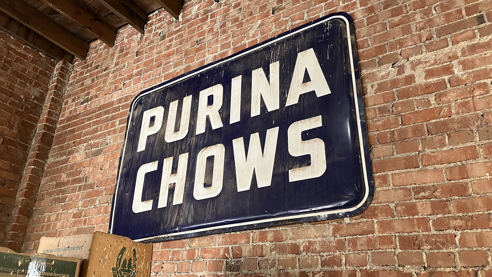An old Purina Chows sign on the wall in the warehouse.
