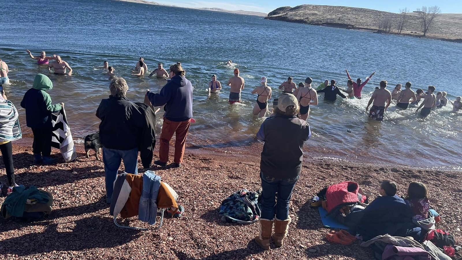 Not everyone takes the plunge during the annual Lake De Smet Polar Plunge on New Year's Day. A few like to watch and take photos of the occasion And hold up dry towels for those exiting the cold water.