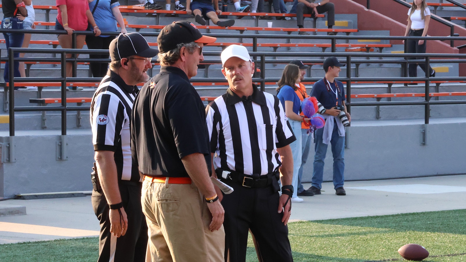 Umpire Warren Crawford, left, and referee Todd Pearson, right, talk with Natrona County High School head football coach Steve Harshman before the game.