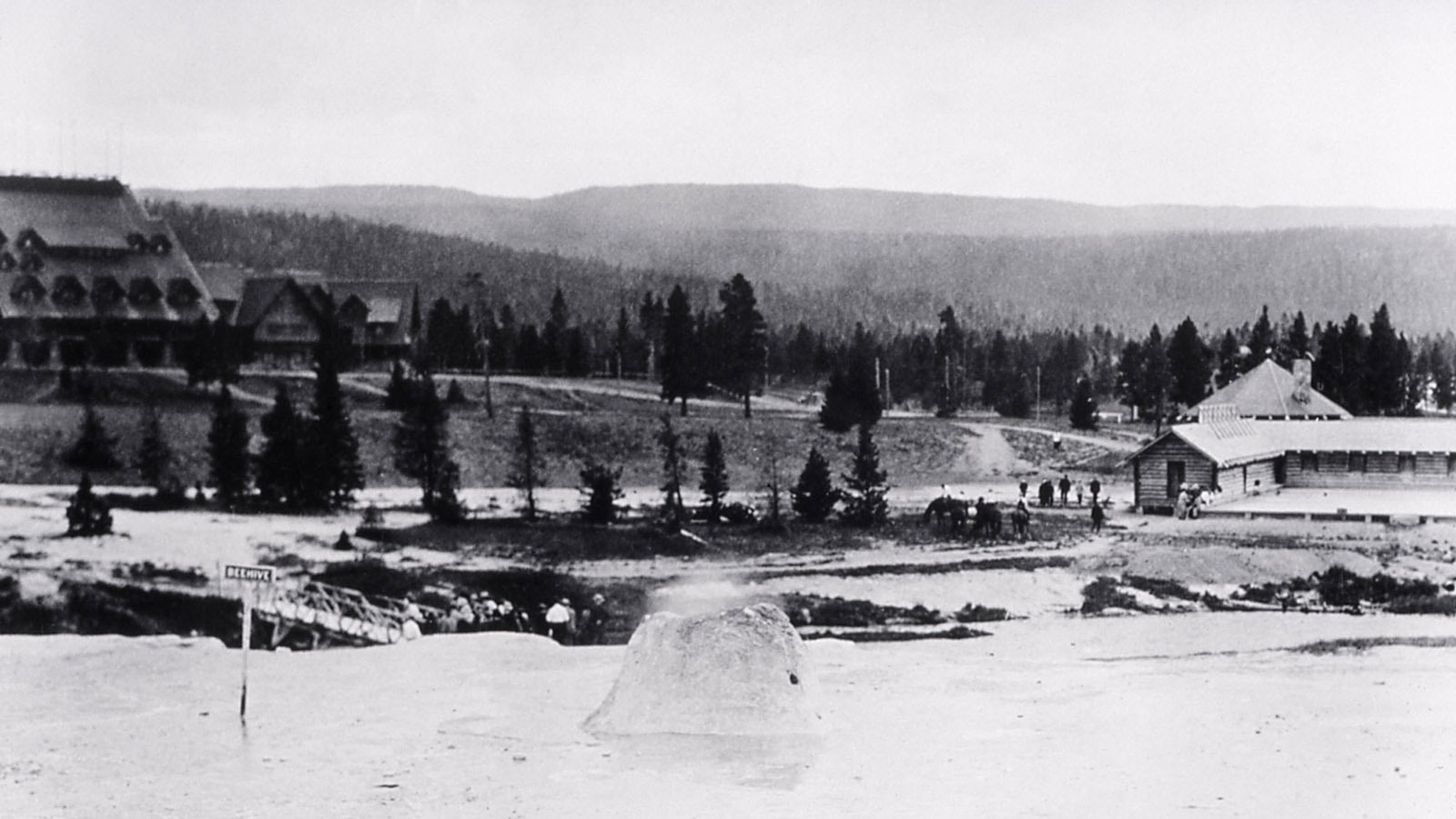 Old Faithful Inn, swimming pool and store, with Beehive Geyser in the foreground, in 1921.