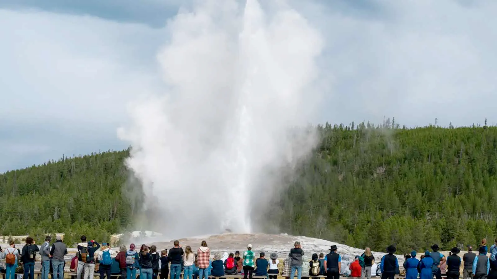 Tourists gather to watch Old Faithful geyser erupt on Oct. 10, 2024, in Yellowstone National Park.