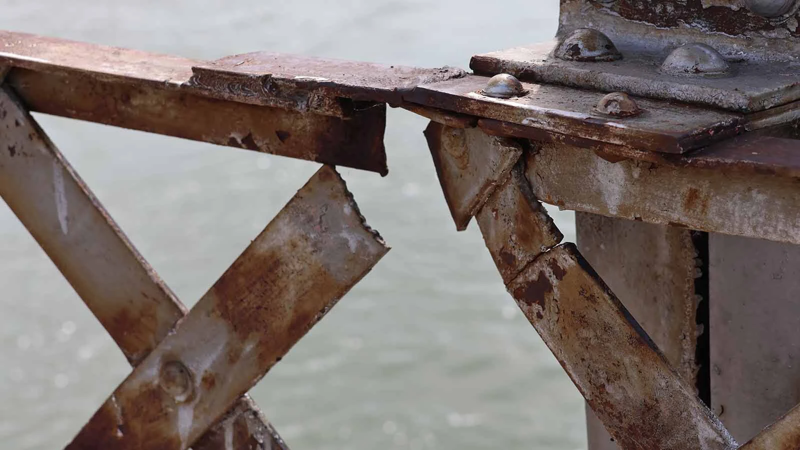 The broken metal on the side of the bridge shows its century-old age.