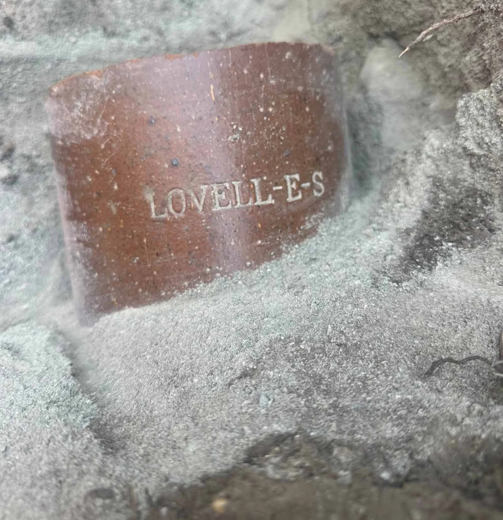 A piece of clay pipe uncovered in Glacier National Park, bearing the stamp of the Lovell Clay Products Company.