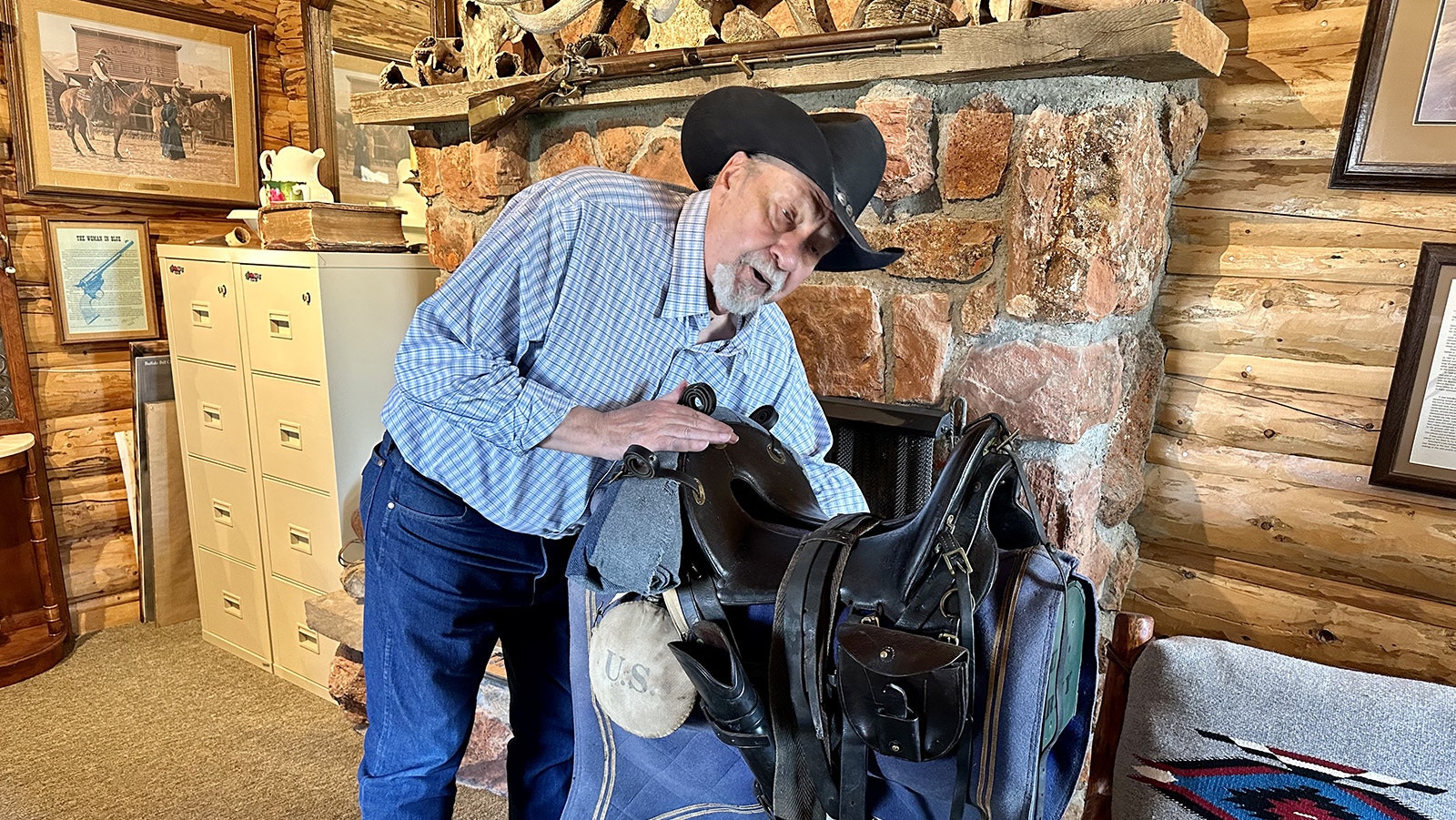 Old Trail Town's Treasurer Larry Edgar shows off an 1875 U.S. Calvary saddle recently donated to the museum. Old Trail Town is owned and operated by the nonprofit Museum of the Old West, founded by Larry's brother, Bob Edgar.