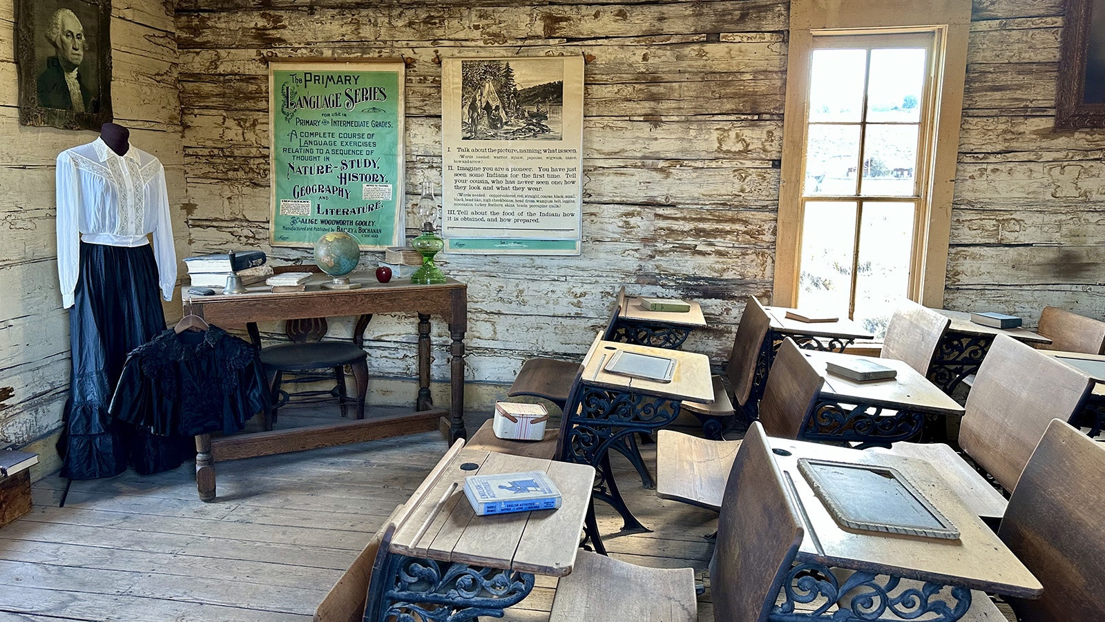 The interior of the Coffin School at Old Trail Town, originally located in Meeteetse. The dress and blouse on display were a recent discovery in one of the many unopened chests scattered throughout the complex.