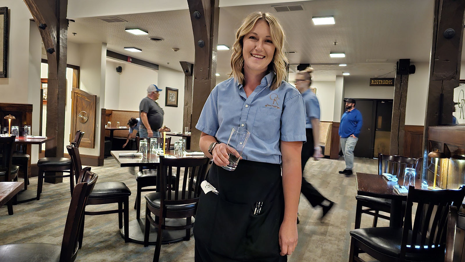 Jessica, a waitress at Open Range, holding a glass that took a tumble off the table to her right. Both the glass and the table were dry, and there was no wobbly leg, nor was there anyone visible near the table at the time.