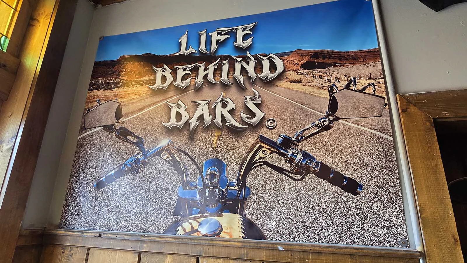 This picture in the corner of the Bone Daddy Outlaw Bar in Dubois sums up the new owner's motto in life.
