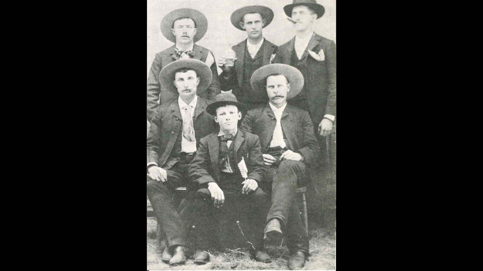 Dick Nelson, center front, was just 13 years old when his father brought him to visit their neighbors on Christmas Eve. The men were known fugitives from the law and the leader, Buck Hanby, claimed that it was all a misunderstanding. Hanby was appreciative of the Christmas visit and the gifts of doughnuts and cookies Dick’s mother had made for them. Here he's pictured with coworkers at a sawmill.