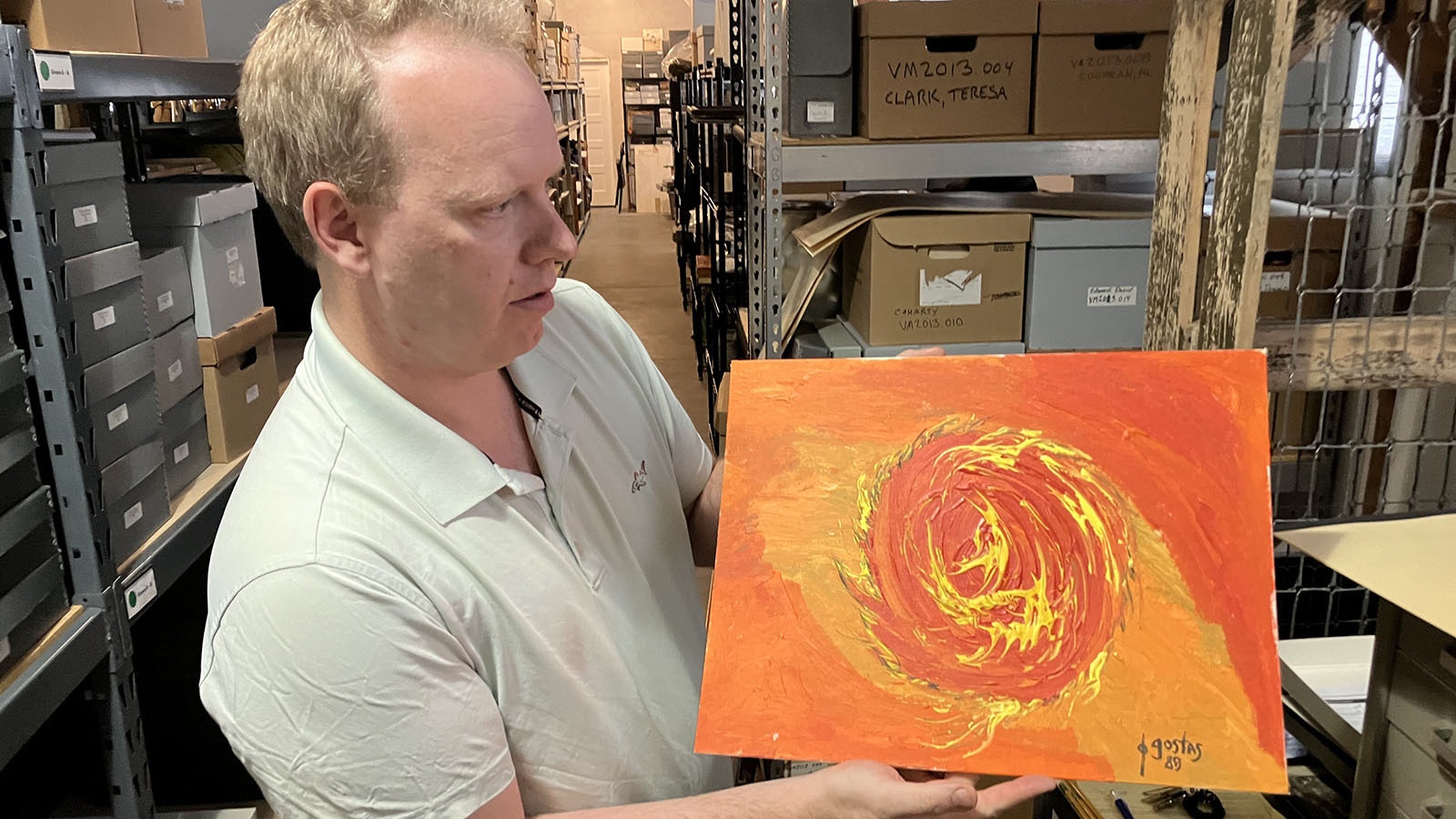 Wyoming Veterans Memoiral Museum Director John Woodward holds a painting by Ted Gostas that is in the museum’s collection.