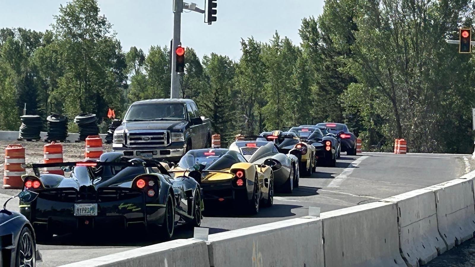 A lineup of $4 million Pagani supercars navigating construction in Jackson, Wyoming, in summer 2024.