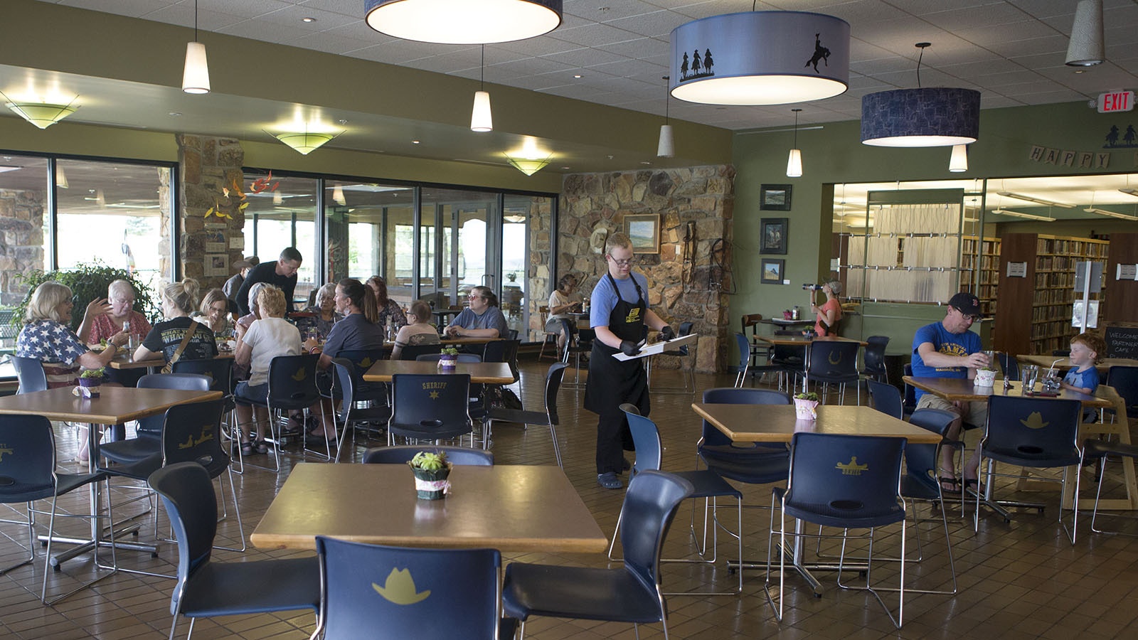 Pardner Colin Christensen, center, heads back to the kitchen after serving food recently at the Pardners Cafe in Cody. The cafe provides vocational training and experience for adults with developmental disabilities.