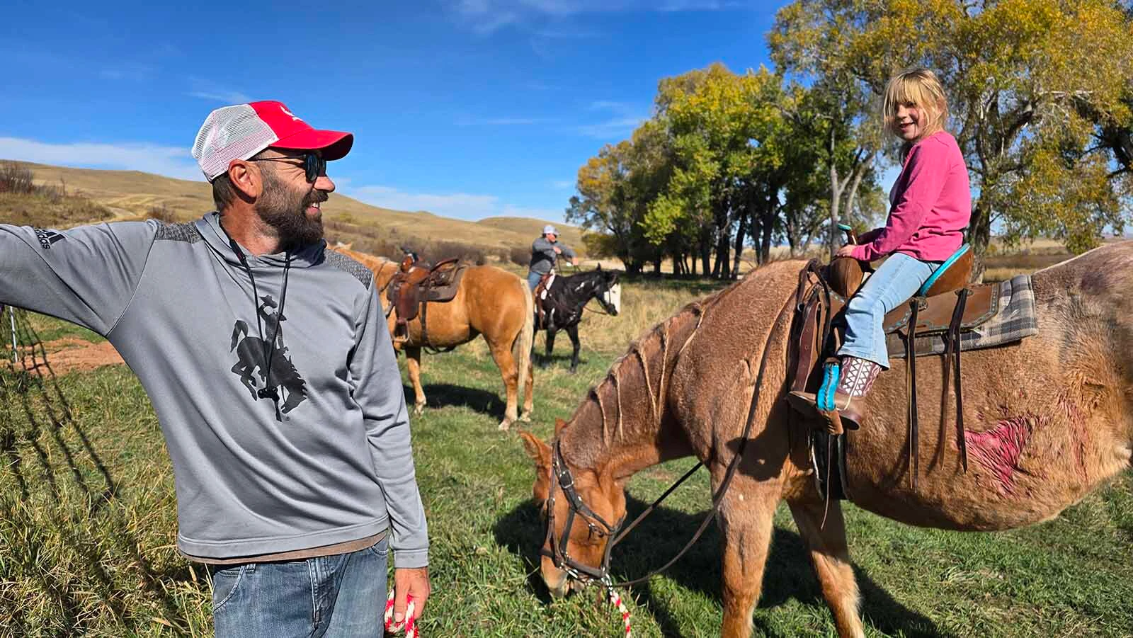 Richhie Bratton laughs at his daughter Dorothy when she suggests he could have run a little faster. Meanwhile, the horse named Sweetgrass ignores both of them and just keeps muching on her grass.