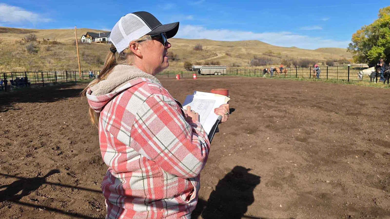 Chelsea Warner keeps track of each entry's time during the Double Rafter Ranch's neighborhood block party and rodeo. It was bring a dish, bring your own beverage,  and, if you have one, bring your own horse.