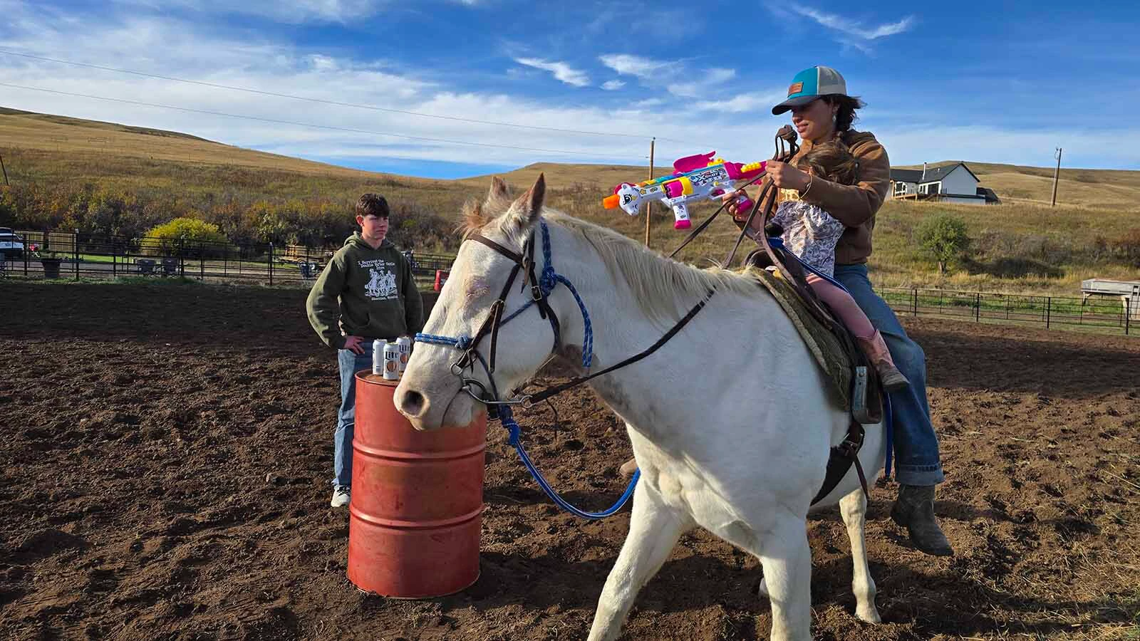 A mom helps her daughter with the pink unicorn nerf gun during the gunfight at the Double Rafter Ranch's neighborhood block party and rodeo.