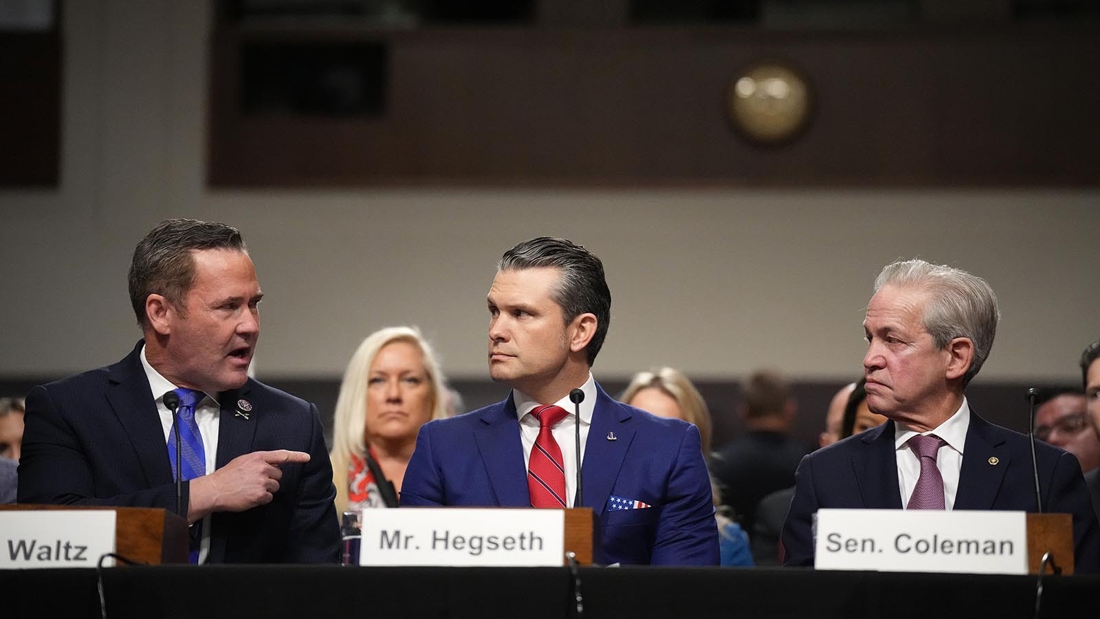 Pete Hegseth, President-elect Donald Trump's pick for Defense secretary, testifies Tuesday for the Senate Armed Services Committe. Here he's introduced by Rep. Michael Waltz, R-Florida, left, and with Sen. Norm Coleman, R-Minnesota, right.