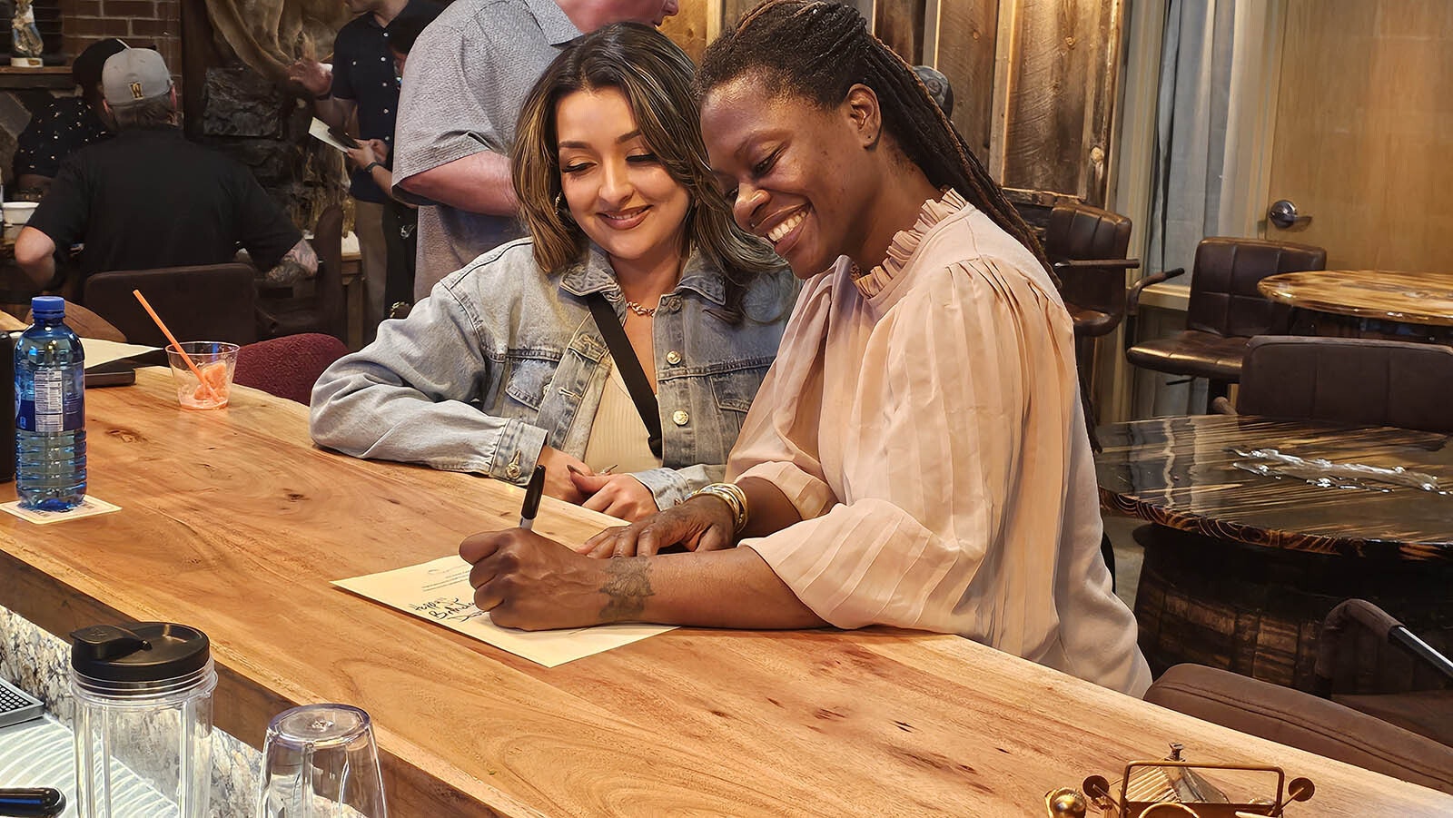 Chef Petrina Peart, right, autographs the menu for her latest "Yes, Chef!" watch party.