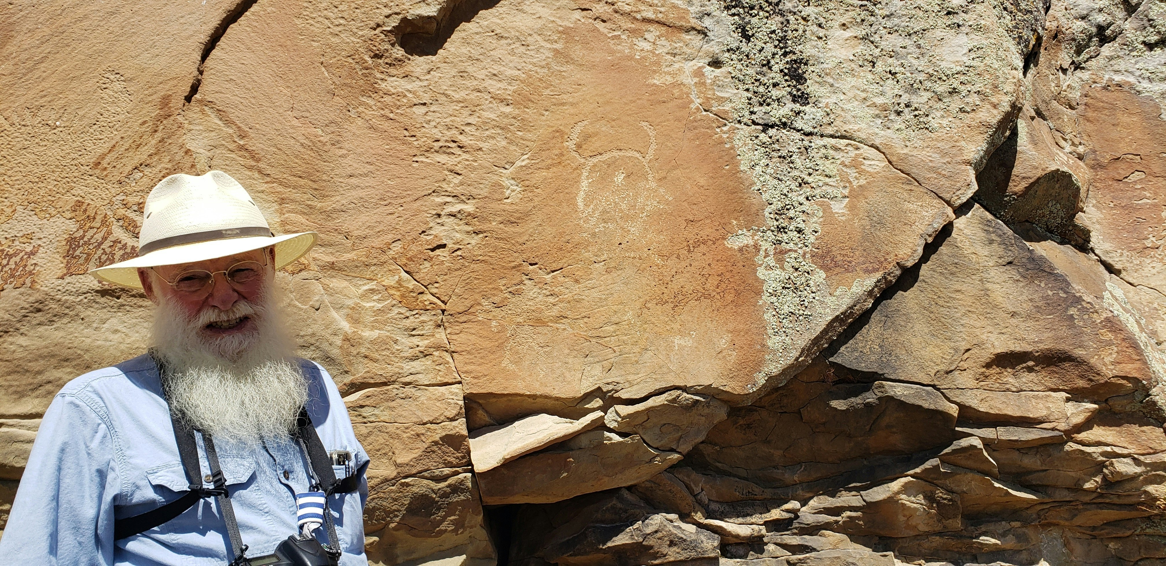 Mike Bies with one of the Wind River Indian Reservation petroglyphs that's threatening to break off the canyon wall.