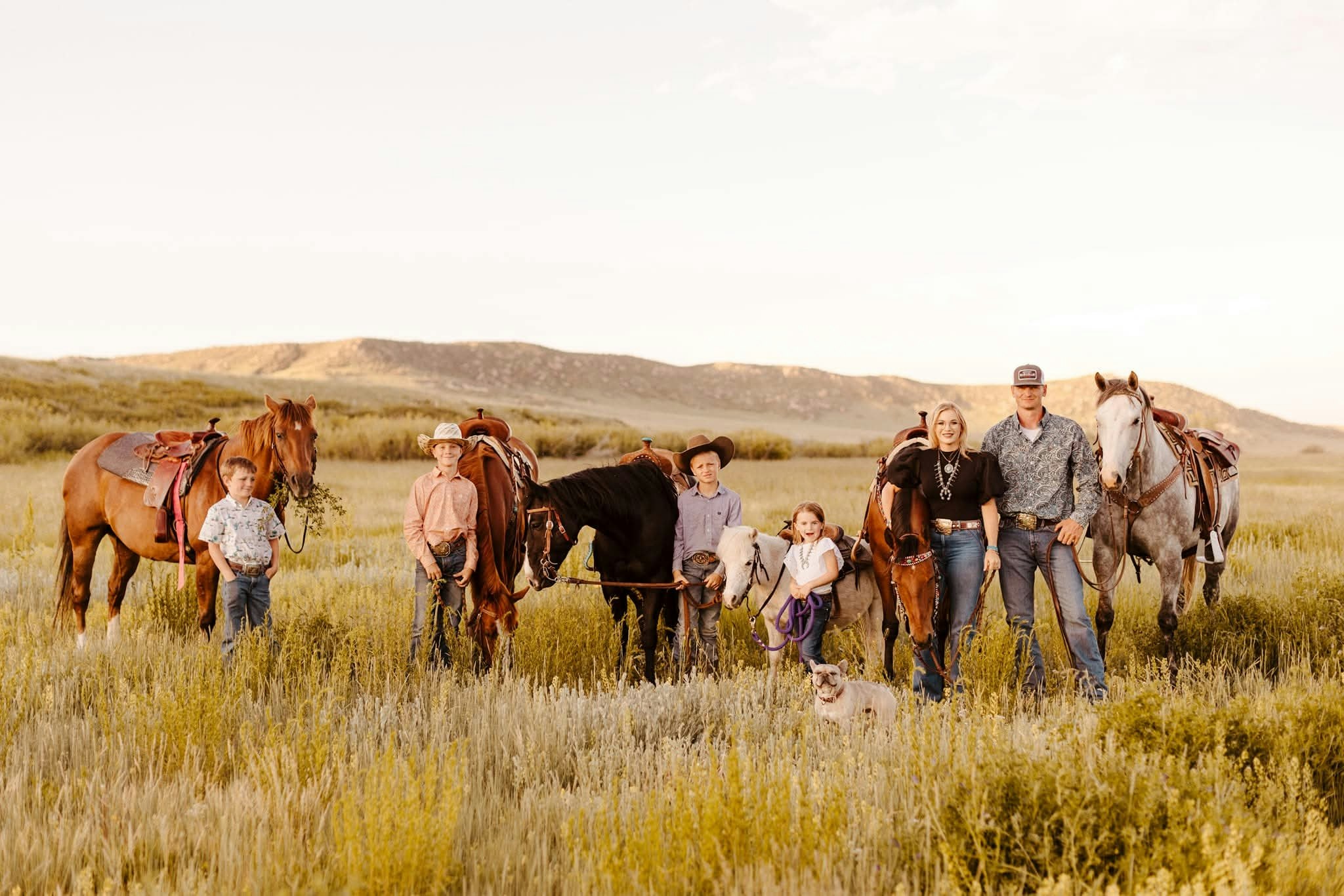 French bulldog Doc Holliday poses with his cattle ranching family. Doc Holliday herds cattle far larger than him and is just one of Happy Valleys many celebrity dogs.