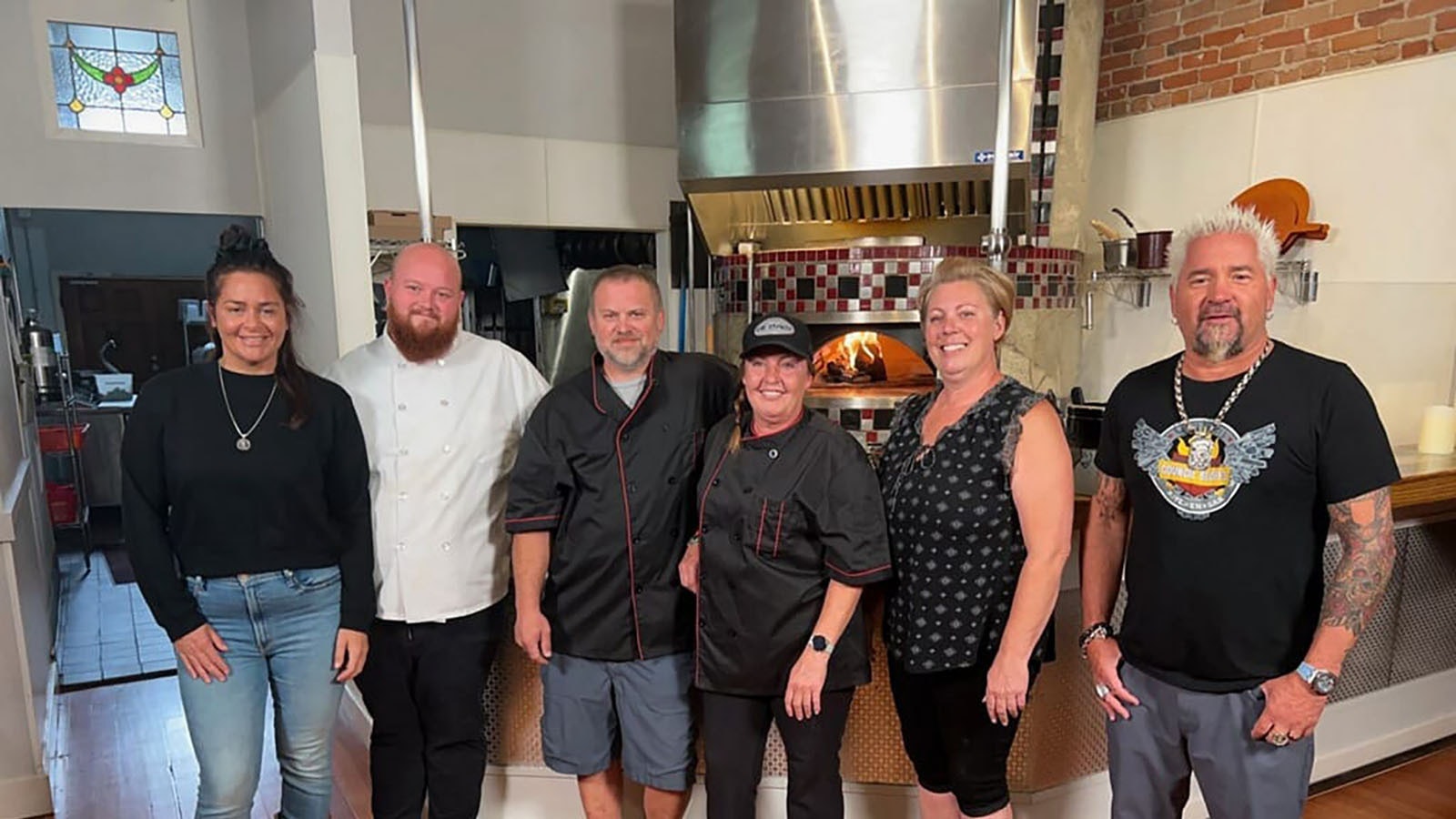Food Network star Guy Fieri, far right, with the Pie Zanos owner Renée Tiller, center, and her crew in Buffalo, Wyoming.