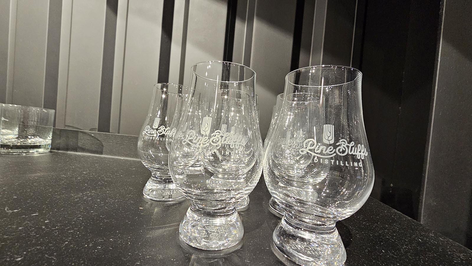 Whiskey glasses are for sale as well at Pine Bluffs Distilling. Similar to wine glasses, the shape helps keep scent molecules together, so that the whiskey may be more fully tasted and enjoyed.