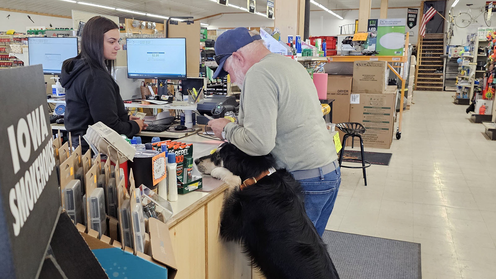 Coop hangs out at the cash register with a customer after delivering a package to the cashier for him.