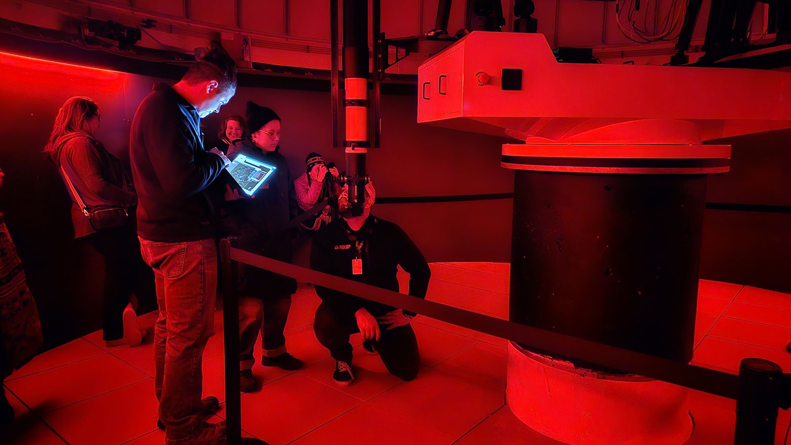 Planetarium Director Joe Zator adjusts a setting on the 1-meter telescope with his laptop.