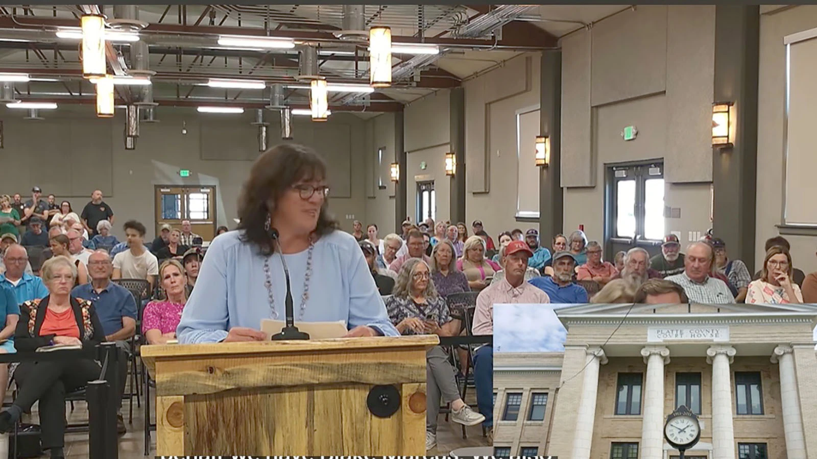 Platte County planner Laura Bookout addresses the Planning and Zoning Commission in front of the packed Agriplex building in Wheatland on Wednesday.