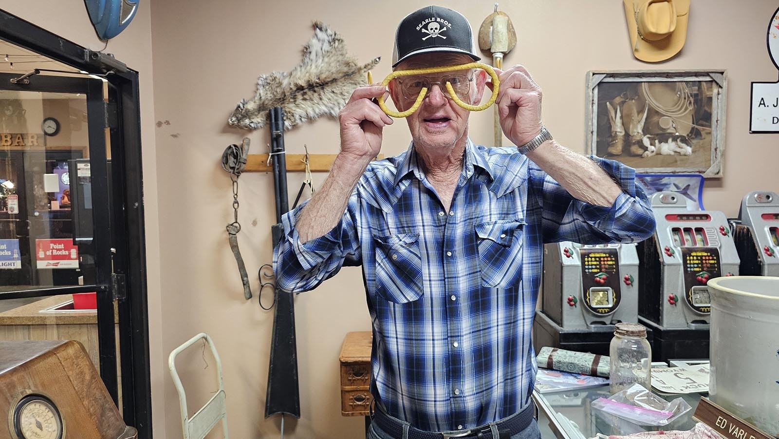 Ed Varley tries on the glasses he made for the 9-foot-cowboy that points the way to the Conoco Station at Point of Rocks.