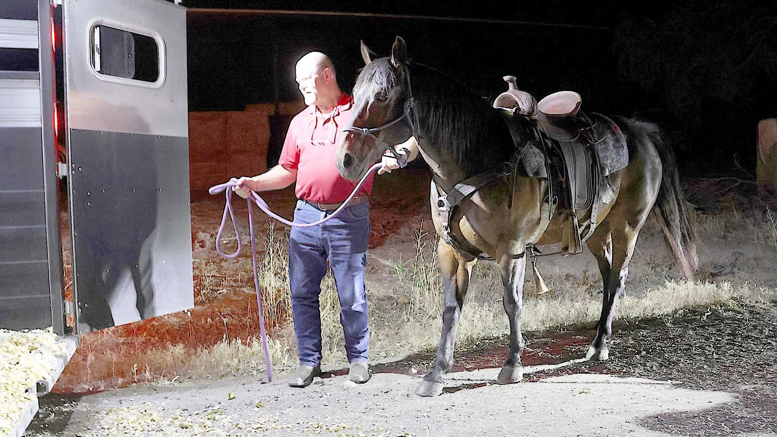 Scott Montgomery loads his wife’s horse.