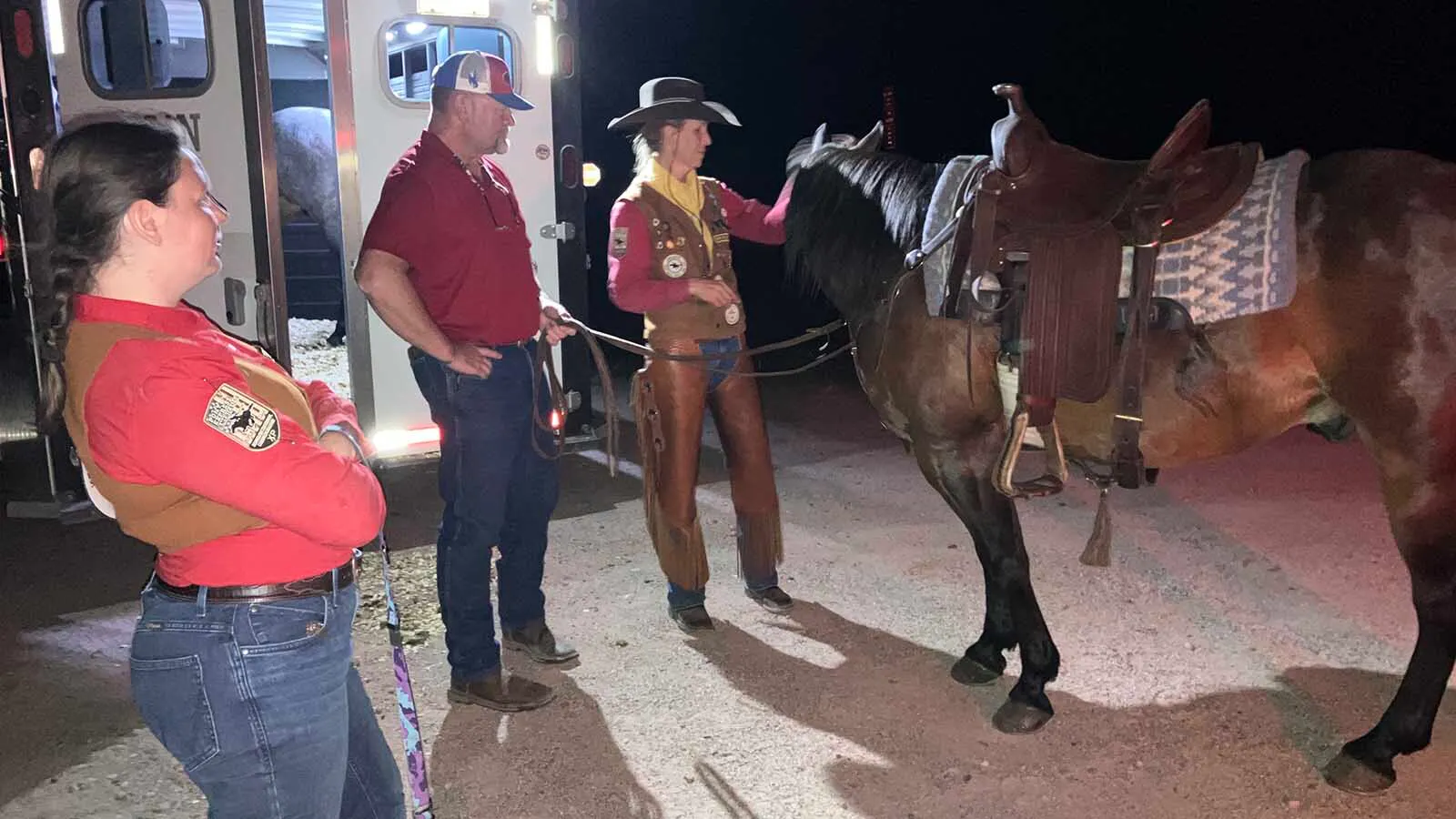 Stephanie Montgomery, right, gets her horse ready to receive the mochila about 1:30 a.m. on Friday as husband, Scott, and fellow rider, Jolene Mathies look on.