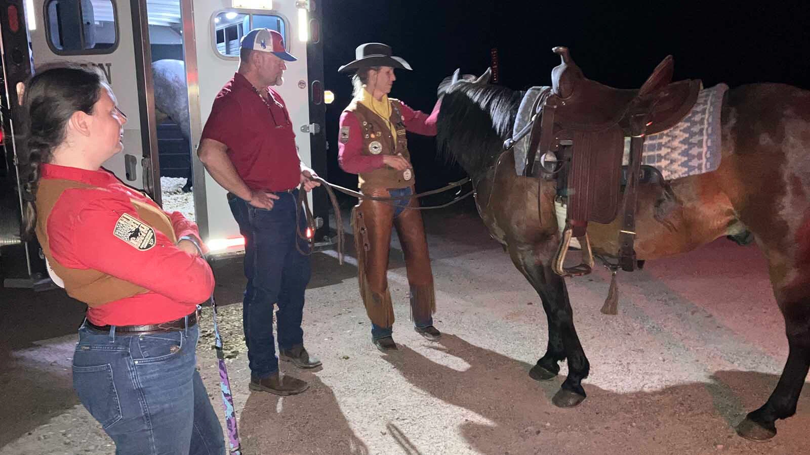 Stephanie Montgomery, right, gets her horse ready to receive the mochila about 1:30 a.m. on Friday as husband, Scott, and fellow rider, Jolene Mathies look on.