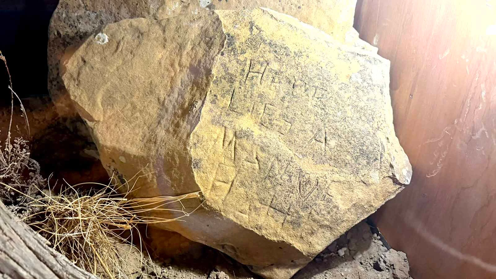 In 1978, Dee Ann Thomas and Debbie Schwanke found this sandstone rock inscribed "Here Lies a Man of Battle" on top of Pappy-Po Butte non the Pitchfork Ranch near Meeteetse. It is now on display at the Old Trail Town in Cody.