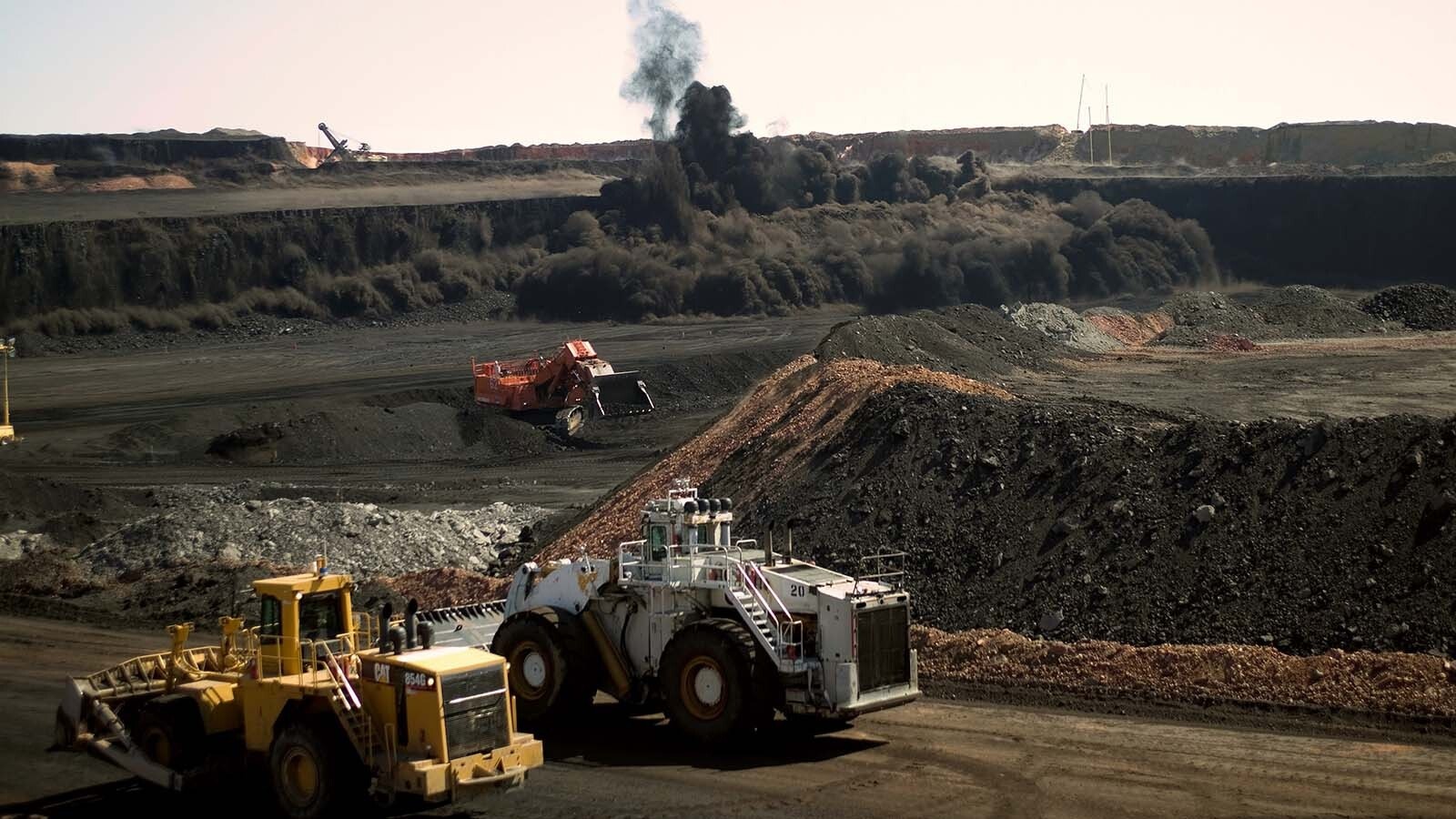 Heavy vehicles stop moving as a timed detonation brings down a wide coal face at the Buckskin Coal Mine in Gillette, Wyoming, in this file photo.