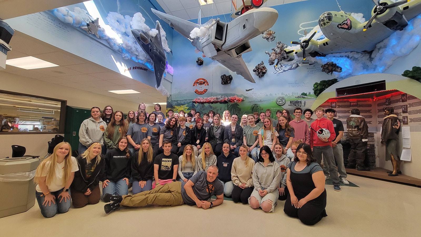 Powell High School art teacher Jim Gilman is pictured with this year's art students in the airplane display room. For more than 10 years art students have created large pieces that are hung up around the school.