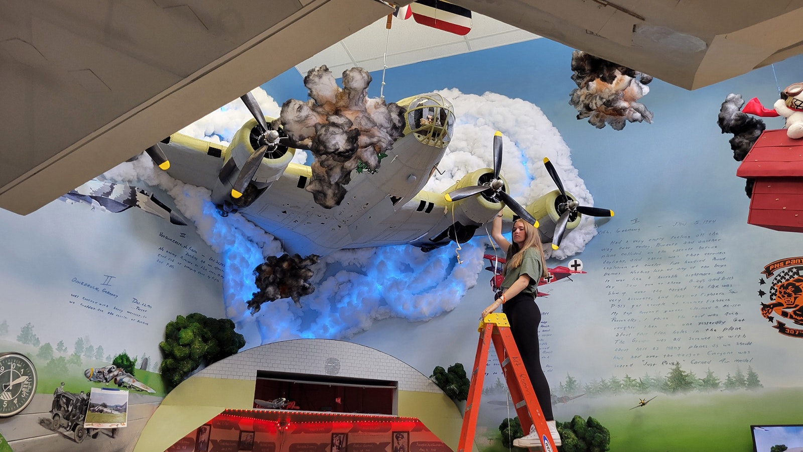 A B-17 Flying Fortress coming out of the wall is one of the vocational art student's latest pieces.