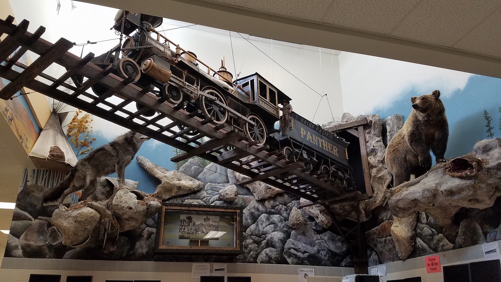 A steam locomotive with moving wheels sits above the Western-themed display.