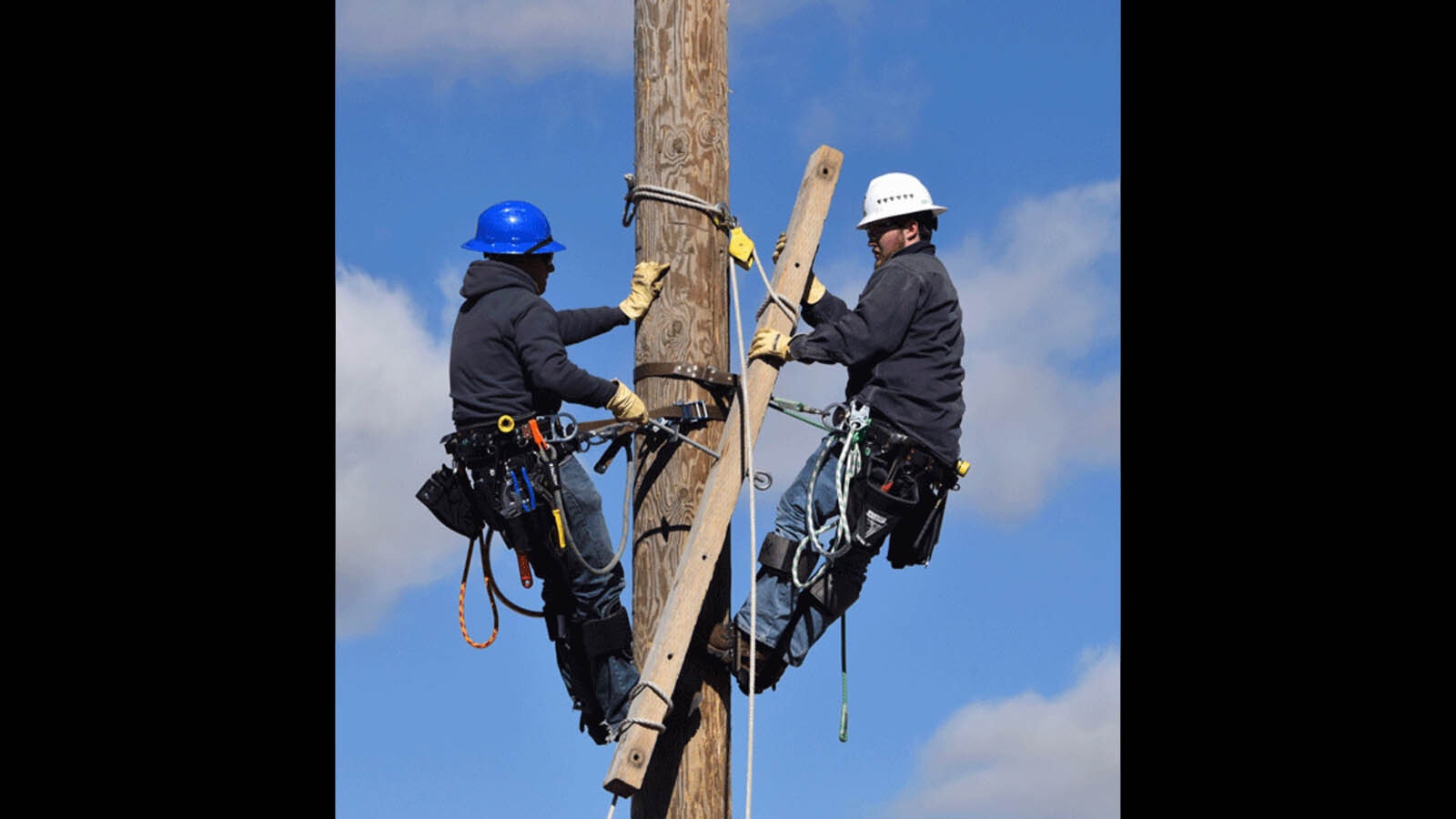 A pair of Western Wyoming Community College Powerline Technology Program students work on a pole.
